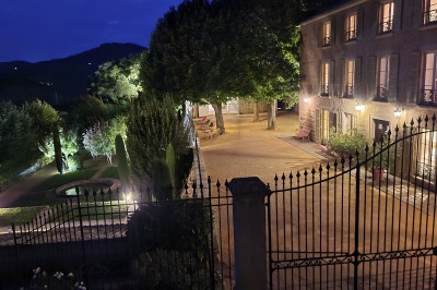 Miniature Location salle Beaujeu (Rhône) - Le Domaine de Vavril #34 Salle voûtée en pierre avec un sol en béton poli, éclairée par des lumières chaudes, et un vase de fleurs au centre.