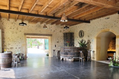 Miniature Location salle Beaujeu (Rhône) - Le Domaine de Vavril #37 Salle voûtée en pierre avec un sol en béton poli, éclairée par des lumières chaudes, et un vase de fleurs au centre.