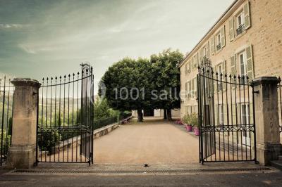 Miniature Location salle Beaujeu (Rhône) - Le Domaine de Vavril #4 Salle voûtée en pierre avec un sol en béton poli, éclairée par des lumières chaudes, et un vase de fleurs au centre.