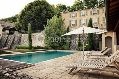 Miniature Location salle Beaujeu (Rhône) - Le Domaine de Vavril #2 Salle voûtée en pierre avec un sol en béton poli, éclairée par des lumières chaudes, et un vase de fleurs au centre.