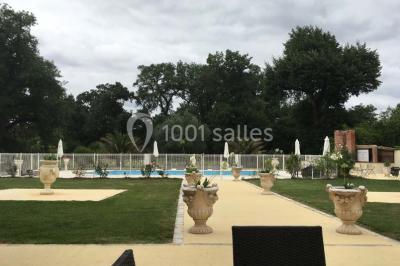 Couloir avec parquet en bois, murs verts décorés, table avec cadres et bougies, et rideaux verts aux fenêtres.