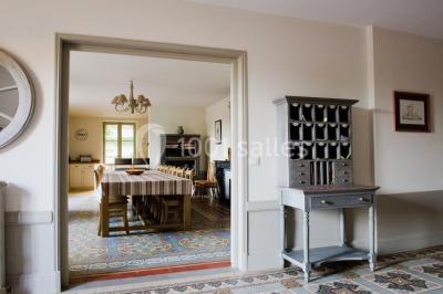 Groupe de personnes réunies en extérieur autour d'un bassin, avec vue sur des collines verdoyantes en arrière-plan.