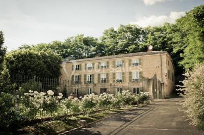 Groupe de personnes réunies en extérieur autour d'un bassin, avec vue sur des collines verdoyantes en arrière-plan.