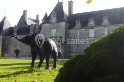 Façade d'un château illuminée par des lumières rouges, avec des drapeaux et des spectateurs en arrière-plan.