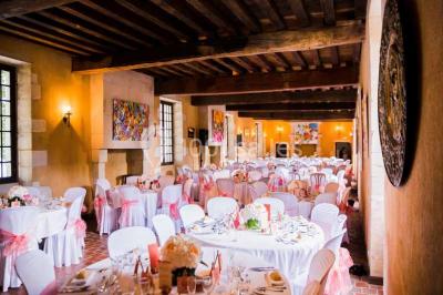 Façade d'un château illuminée par des lumières rouges, avec des drapeaux et des spectateurs en arrière-plan.