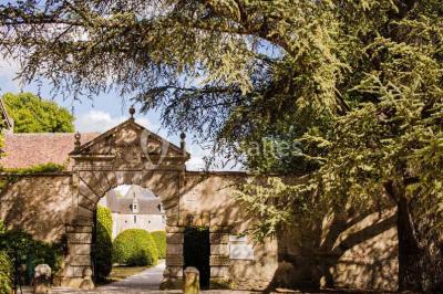 Façade d'un château illuminée par des lumières rouges, avec des drapeaux et des spectateurs en arrière-plan.