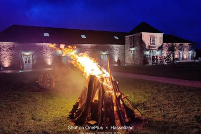 Cour extérieure éclairée par des guirlandes lumineuses, avec des invités rassemblés près de tables hautes.