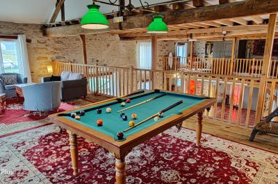 Cour extérieure éclairée par des guirlandes lumineuses, avec des invités rassemblés près de tables hautes.