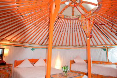 Cour extérieure éclairée par des guirlandes lumineuses, avec des invités rassemblés près de tables hautes.