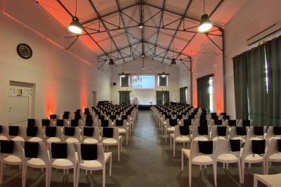 Cour extérieure éclairée par des guirlandes lumineuses, avec des invités rassemblés près de tables hautes.