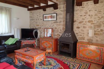 Cour extérieure éclairée par des guirlandes lumineuses, avec des invités rassemblés près de tables hautes.