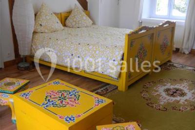 Cour extérieure éclairée par des guirlandes lumineuses, avec des invités rassemblés près de tables hautes.