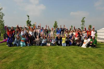 Cour extérieure éclairée par des guirlandes lumineuses, avec des invités rassemblés près de tables hautes.
