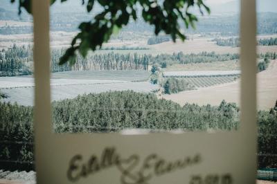 Table en pierre sous une voûte en pierre, avec un pot de fleurs et des outils anciens accrochés au mur.