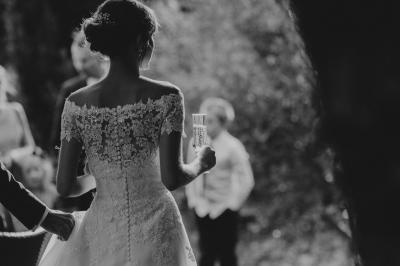 Table en pierre sous une voûte en pierre, avec un pot de fleurs et des outils anciens accrochés au mur.