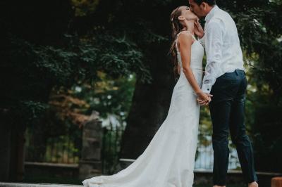 Table en pierre sous une voûte en pierre, avec un pot de fleurs et des outils anciens accrochés au mur.