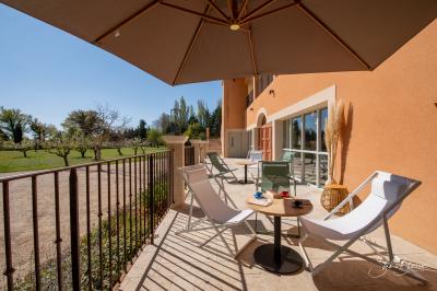 Salle lumineuse avec mobilier en bois et rotin, canapés blancs, décorations naturelles et grandes fenêtres donnant sur l…