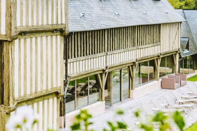 Panier de fruits frais sur une table en verre avec deux cocktails colorés, entouré de fauteuils en rotin.
