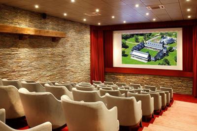 Panier de fruits frais sur une table en verre avec deux cocktails colorés, entouré de fauteuils en rotin.