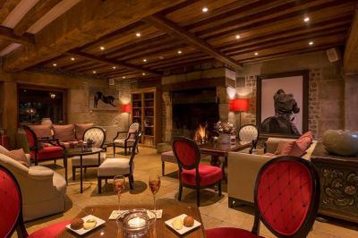 Panier de fruits frais sur une table en verre avec deux cocktails colorés, entouré de fauteuils en rotin.