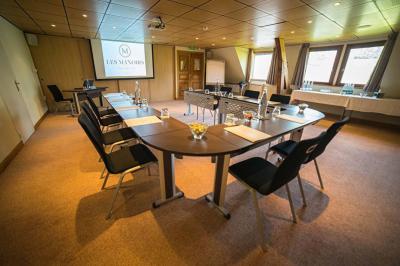 Panier de fruits frais sur une table en verre avec deux cocktails colorés, entouré de fauteuils en rotin.