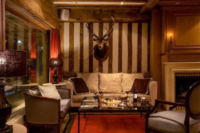 Panier de fruits frais sur une table en verre avec deux cocktails colorés, entouré de fauteuils en rotin.