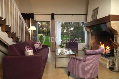 Panier de fruits frais sur une table en verre avec deux cocktails colorés, entouré de fauteuils en rotin.