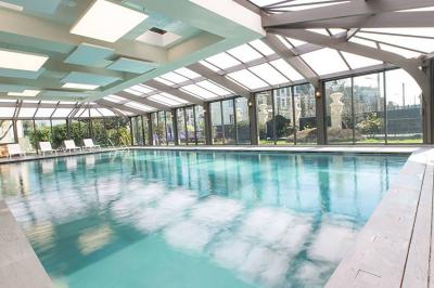 Vue aérienne de Saint-Malo, montrant les remparts, la plage, le port et les environs côtiers sous un ciel dégagé.