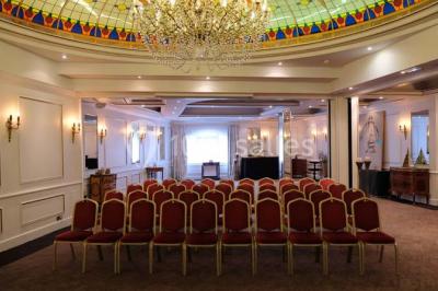 Un homme court sur un tapis de course dans un spa, une femme en peignoir est assise en arrière-plan.