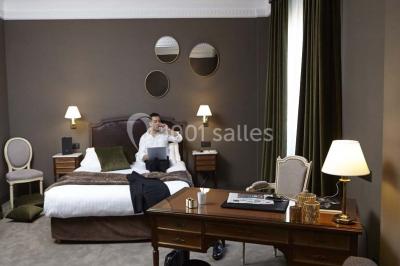 Un homme court sur un tapis de course dans un spa, une femme en peignoir est assise en arrière-plan.