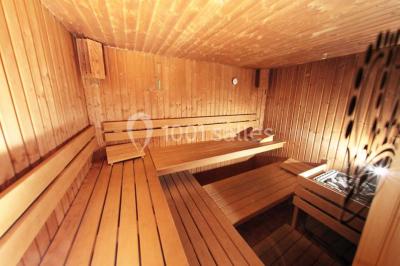 Un homme court sur un tapis de course dans un spa, une femme en peignoir est assise en arrière-plan.