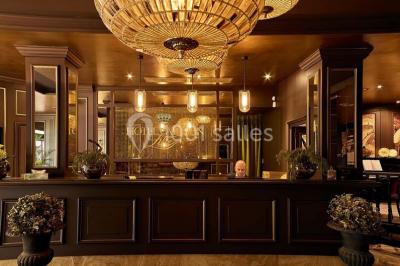 Un homme court sur un tapis de course dans un spa, une femme en peignoir est assise en arrière-plan.