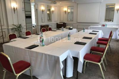 Un homme court sur un tapis de course dans un spa, une femme en peignoir est assise en arrière-plan.