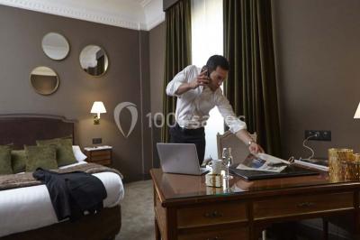 Un homme court sur un tapis de course dans un spa, une femme en peignoir est assise en arrière-plan.