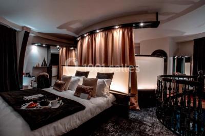 Un homme court sur un tapis de course dans un spa, une femme en peignoir est assise en arrière-plan.