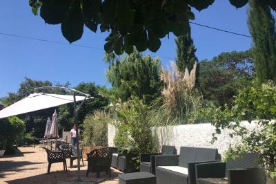 Paysage de coucher de soleil avec des arbres en silhouette, surmonté d'un logo d'équitation et d'informations de contact.