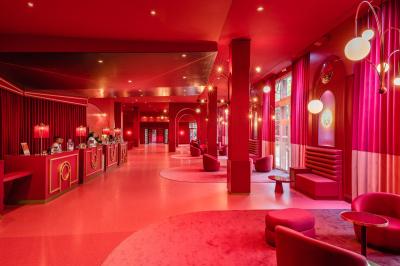 Salle de conférence lumineuse avec rangées de chaises alignées, écran de projection et portes vitrées au fond.