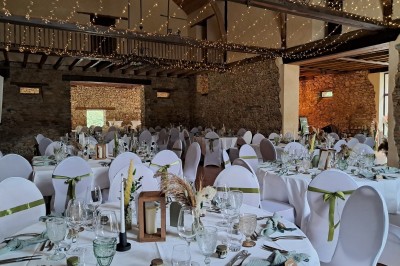 Une mariée danse au centre d'une salle décorée de guirlandes lumineuses, entourée d'invités.