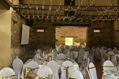 Une mariée danse au centre d'une salle décorée de guirlandes lumineuses, entourée d'invités.