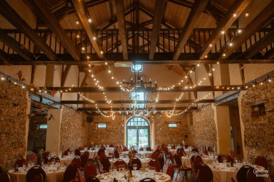 Une mariée danse au centre d'une salle décorée de guirlandes lumineuses, entourée d'invités.