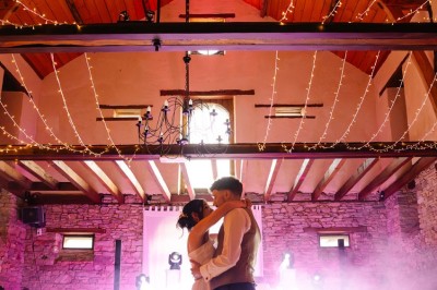 Miniature Location salle Vallons-de-l'Erdre (Loire-Atlantique) - Domaine du Bois d'Andigné #8 Une mariée danse au centre d'une salle décorée de guirlandes lumineuses, entourée d'invités.