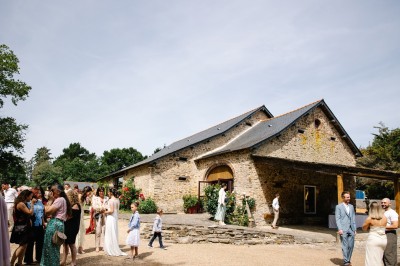 Miniature Location salle Vallons-de-l'Erdre (Loire-Atlantique) - Domaine du Bois d'Andigné #10 Une mariée danse au centre d'une salle décorée de guirlandes lumineuses, entourée d'invités.