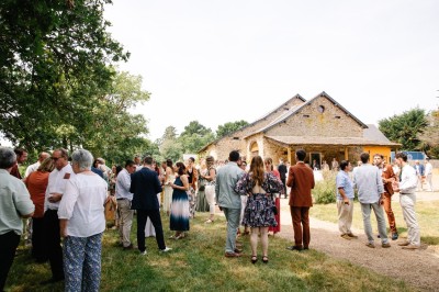 Miniature Location salle Vallons-de-l'Erdre (Loire-Atlantique) - Domaine du Bois d'Andigné #12 Une mariée danse au centre d'une salle décorée de guirlandes lumineuses, entourée d'invités.