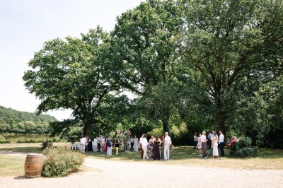 Miniature Location salle Vallons-de-l'Erdre (Loire-Atlantique) - Domaine du Bois d'Andigné #33 Une mariée danse au centre d'une salle décorée de guirlandes lumineuses, entourée d'invités.