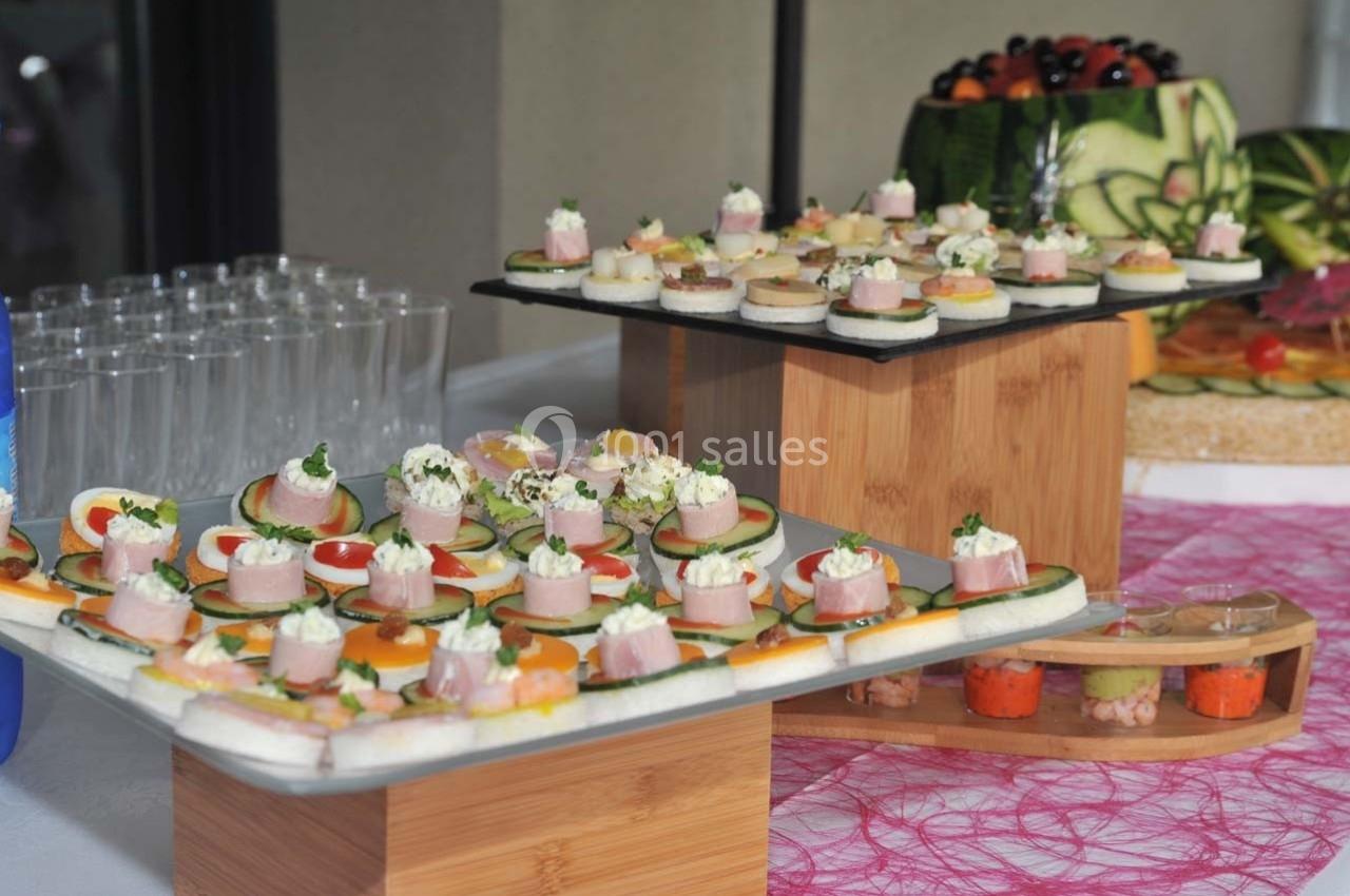 Plateaux de canapés variés avec légumes, fromage et charcuterie, disposés sur une table décorée.
