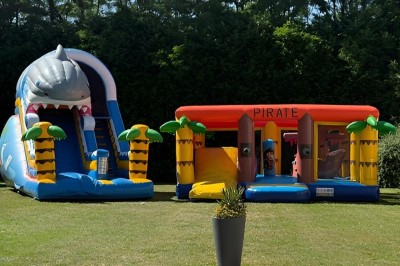 Miniature Location salle Brie-Comte-Robert (Seine-et-Marne) - Domaine de la Gillardière #31 Chambre moderne avec lit double, mur violet, grande fenêtre donnant sur un jardin et sol en carrelage gris.