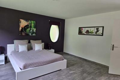 Miniature 3 : Chambre nuptiale Chambre moderne avec lit double, mur violet, grande fenêtre donnant sur un jardin et sol en carrelage gris.