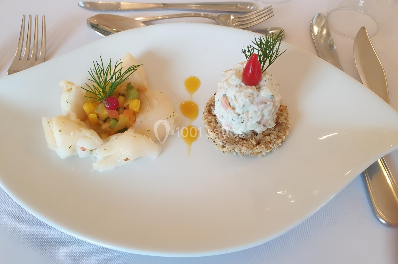 Assiette gastronomique avec poisson, tartare sur biscuit croustillant, légumes colorés et décorations d'aneth.