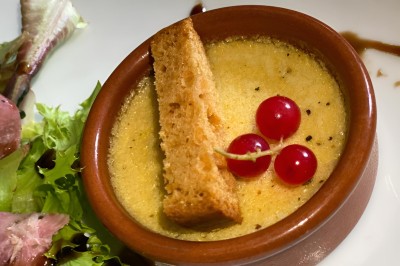 Miniature Entrée Crème brulée au foie gras Chambre moderne avec lit double, mur violet, grande fenêtre donnant sur un jardin et sol en carrelage gris.