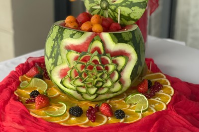 Miniature Soupière de Melon et Pastèque Chambre moderne avec lit double, mur violet, grande fenêtre donnant sur un jardin et sol en carrelage gris.